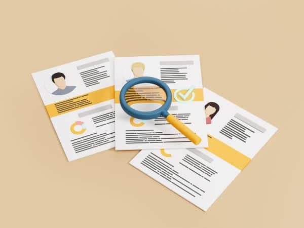 tre contratti di lavoro sotto una lente di ingrandimento, simbolo di assunzione