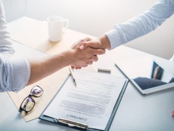 Stretta di mano sopra un contratto di lavoro dopo una consulenza