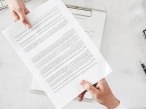 Una persona tiene in mano un contratto di prestazione di servizi 