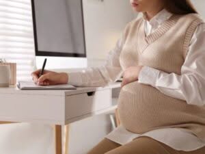 donna incinta al lavoro pronta per richiedere un congedo maternità