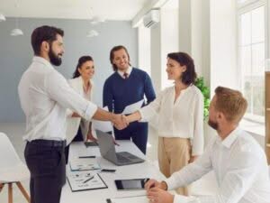 Dipendenti che si stringono la mano in ufficio, simbolo di riassunzione dopo un licenziamento nella stessa azienda
